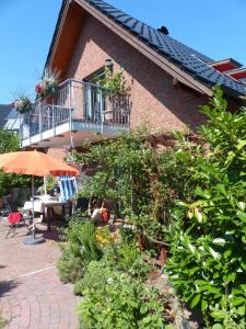 a patio with a table and an umbrella and a building at Loft Sierksdorf in Sierksdorf