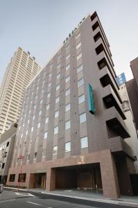 un grand bâtiment avec un panneau sur son côté dans l'établissement Sotetsu Fresa Inn Nihombashi-Ningyocho, à Tokyo