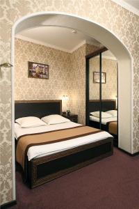 a bedroom with a large bed and a mirror at Eliseeff Arbat Hotel in Moscow