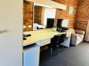 an office with a desk with a computer and a mirror at Broadford Sugarloaf Motel in Broadford