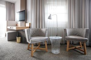 - deux chaises et un bureau dans une chambre d'hôtel dans l'établissement Hotel Jakob, à Fuschl am See