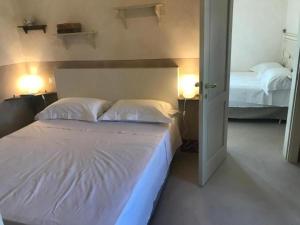 1 dormitorio con 2 camas y 2 luces en la pared en Tenuta Castelle, en Cutrofiano
