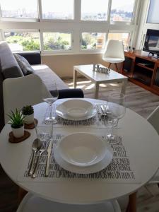 トレモリノスにある¡¡Acogedor apartamento con vistas infinitas!!の白いテーブル(皿、ワイングラス付)