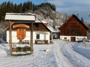 un cartello nella neve davanti a un edificio di Ferienhaus am Reitbauernhof Luckyranch a Mellach