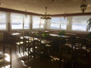 a dining room with tables and chairs and windows at B&B Haus Granit Saas Grund in Saas-Grund