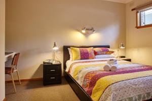 a bedroom with a bed with a desk and a bed sidx sidx sidx at Goldfield Holiday Units in Bright