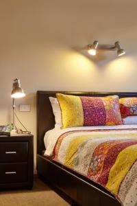 a bedroom with a bed and a lamp at Goldfield Holiday Units in Bright