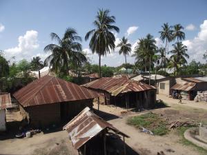 un gruppo di case con palme in un villaggio di Ella's Swahili House a Bagamoyo