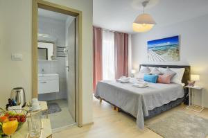 a bedroom with a bed and a bathroom at D&A Amphitheatre Apartments with free parking in Pula