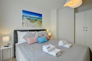 a bedroom with a bed with towels on it at D&A Amphitheatre Apartments with free parking in Pula