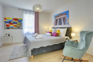 a bedroom with a bed and a blue chair at D&A Amphitheatre Apartments with free parking in Pula