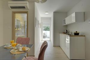 a kitchen and dining room with a table and chairs at D&A Amphitheatre Apartments with free parking in Pula