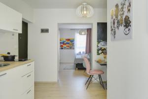 a kitchen with a pink chair and a dining room at D&A Amphitheatre Apartments with free parking in Pula
