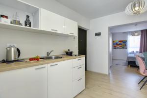 a kitchen with white cabinets and a counter top at D&A Amphitheatre Apartments with free parking in Pula