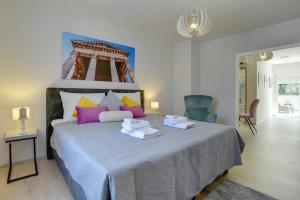 a bedroom with a large bed with towels on it at D&A City Center Apartments with free parking in Pula