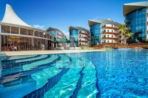 a large swimming pool in a city with buildings at Onkel Rada Apart Hotel in Antalya
