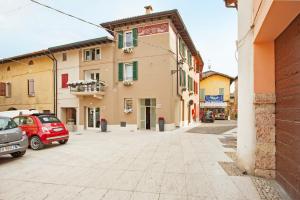 a street with cars parked in front of a building at La Bellavita del Garda Luxury Apartments in San Felice del Benaco +14 photos