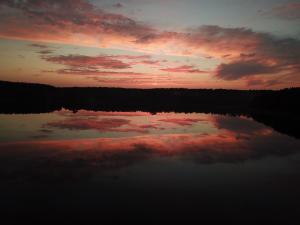 a sunset over a body of water with the sky at Vila Tauragnas in Varniškės I