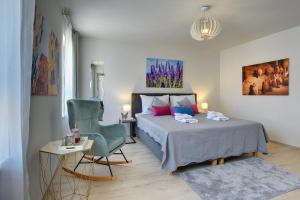 a bedroom with a bed and a chair in it at D&A Amphitheatre Apartments with free parking in Pula