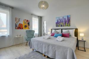 a bedroom with a large bed and a blue chair at D&A Amphitheatre Apartments with free parking in Pula
