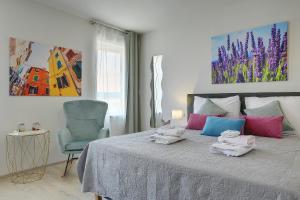 a bedroom with a bed with towels on it at D&A Amphitheatre Apartments with free parking in Pula