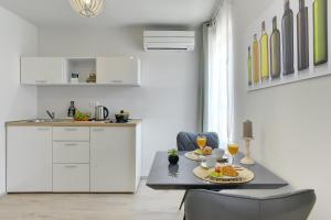 a kitchen with a table with two plates of food on it at D&A Amphitheatre Apartments with free parking in Pula