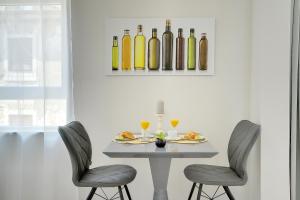 a dining room with a table with two chairs and wine bottles at D&A Amphitheatre Apartments with free parking in Pula