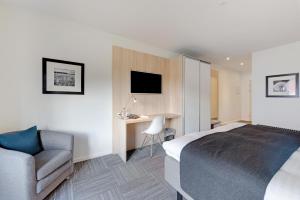 Hotel Jernbanegade في Kibæk: غرفه فندقيه بسرير وكرسي