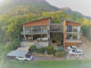 a house with two cars parked in front of it at Thatch View in Hartbeespoort