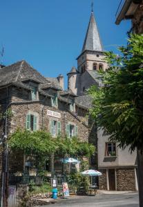 un gran edificio de piedra con una torre en Hotel Solomiac, en Grand-Vabre