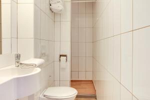 a white bathroom with a toilet and a sink at Hotel Valence Sud in Portes-lès-Valence +21 photos