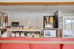 a kitchen with a counter with a microwave and appliances at Hotel Valence Sud in Portes-lès-Valence