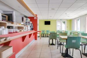 a dining room with tables and chairs in a restaurant at Hotel Valence Sud in Portes-lès-Valence