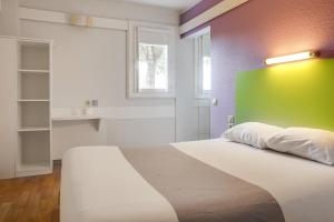 Un dormitorio con una cama con una pared verde. en Hotel Valence Sud, en Portes-lès-Valence