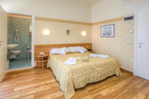 a bedroom with a bed with towels on it at Hotel San Francisco Spiaggia in Rimini