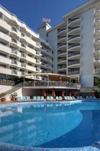 una gran piscina con tumbonas frente a un hotel en Hotel Erma, en Golden Sands