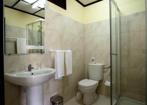 un bagno con lavandino, wc e doccia di Aparthotel Avenida a Mindelo