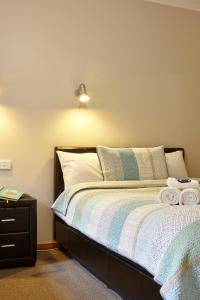 a bedroom with a bed and a dresser at Goldfield Holiday Units in Bright