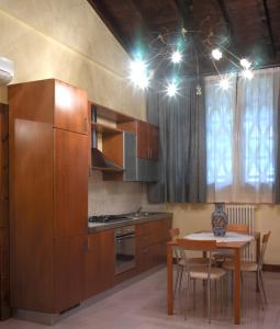 une cuisine avec des placards en bois et une table avec des chaises dans l'établissement Monte Tondo Winery, à Soave
