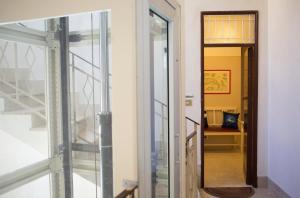 uma porta de vidro que dá para um corredor com um espelho em B&B Piazza Vittorio em Trapani