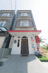 a house with a black door in front of it at Happiness Pediatrics in Xiaoliuqiu