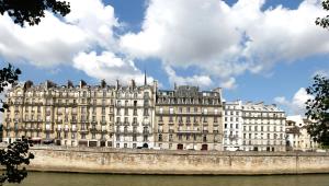 a large building sitting on the side of a river at Hôtel Des Deux-Iles - Notre-Dame in Paris