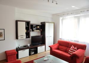 a living room with a red chair and a television at Apartment Sarajka Center in Sarajevo