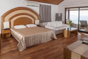 een hotelkamer met een bed en een bank bij Hotel Paradis d'Ouvéa in Fayaoué