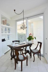 uma sala de jantar com uma mesa e cadeiras e um lustre em Sciccosa Guest House em Taormina