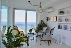 ein Wohnzimmer mit Stühlen, Tischen und Fenstern in der Unterkunft Sciccosa Guest House in Taormina
