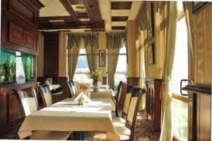 a dining room with two tables and chairs and windows at Hotel Dukov in Obzor