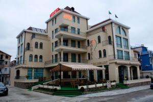 a large building with a restaurant in front of it at Hotel Dukov in Obzor