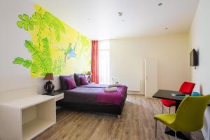 a bedroom with a bed and a desk and a chair at Hotel Cuba Libre in Vijlen