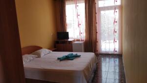 a bedroom with a bed with a towel on it at Casa Dora Costinești in Costinesti